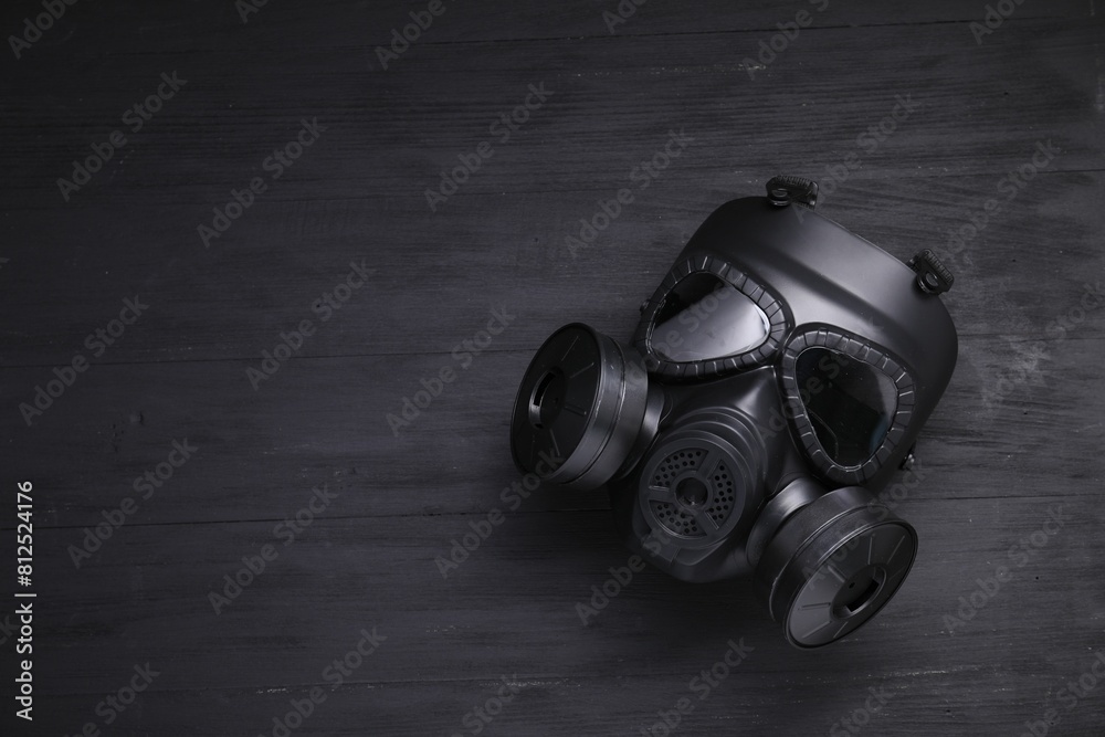 One gas mask on black wooden background, top view. Space for text One gas mask on black wooden background, top view. Space for text