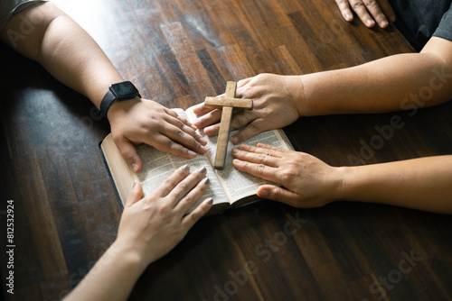 Group of Christian believers clasped hands in prayer, In the church, expressing their faith through worship and reverence for God, symbolized by the cross. Group christian pray concept.