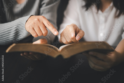 In the church, people to read Bible together, strengthening their faith as devout Catholics united by teachings of holy book. Christians are congregants join hands to pray and seek blessings of God.