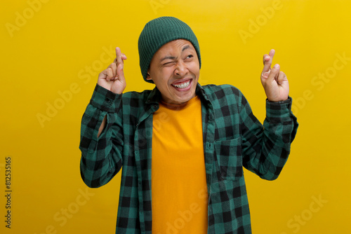 Tablou pe pânză Excited young Asian man, dressed in a beanie hat and casual shirt, expresses ent