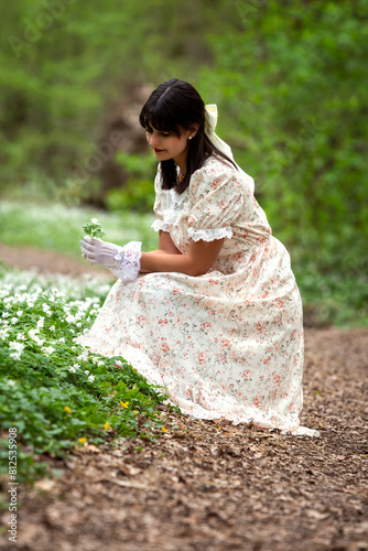 Young lady thoughtfully in the forest full of flowers photo