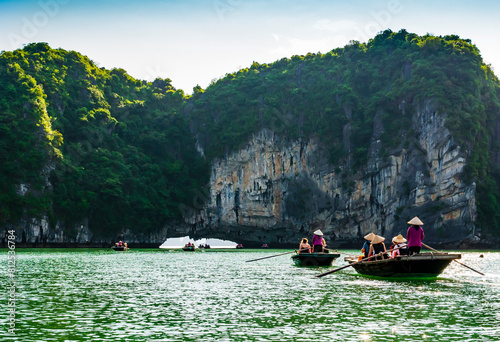 Stunning trip with traditional boats and local purple guides through the multifaceted limestone cliffs of Halong bay, Vietnam