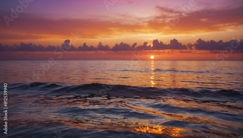 Captivating sunset scene  Tranquil ocean waters beneath a sky ablaze with orange  pink  and purple hues.