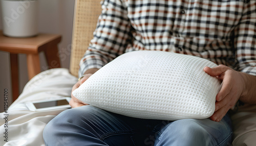 Man with orthopedic memory foam pillow indoors, closeup photo