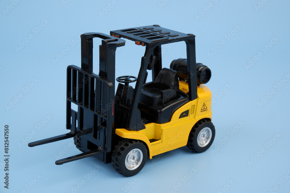 Yellow forklift truck on blue background close-up