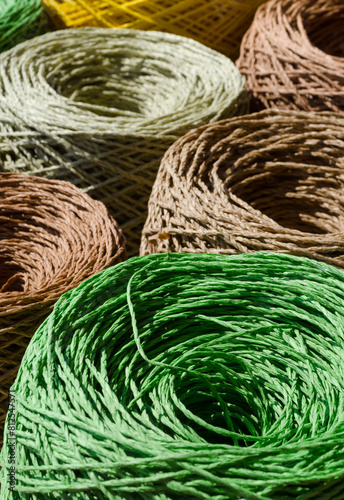 Rolls of colored raffia close-up. Skeins of multi-colored raffia. Eco material for handmade work. © Natalia