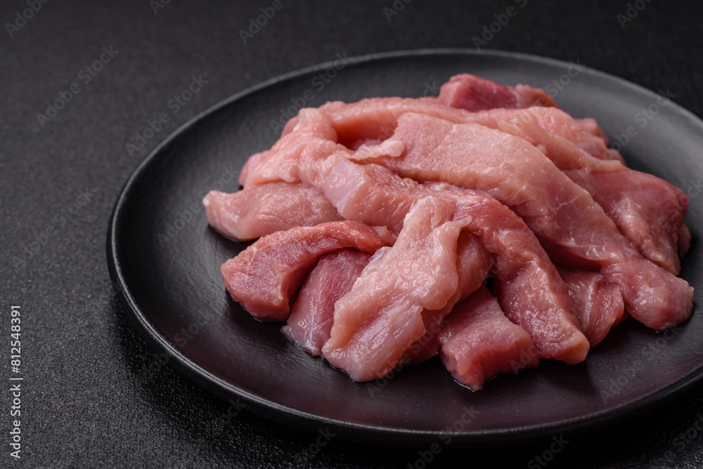 Slices of raw pork or turkey meat with salt, spices and herbs Slices of raw pork or turkey meat with salt, spices and herbs