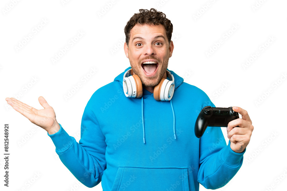 Brazilian man playing with a video game controller over isolated chroma key background with shocked facial expression Brazilian man playing with a video game controller over isolated chroma key background with shocked facial expression