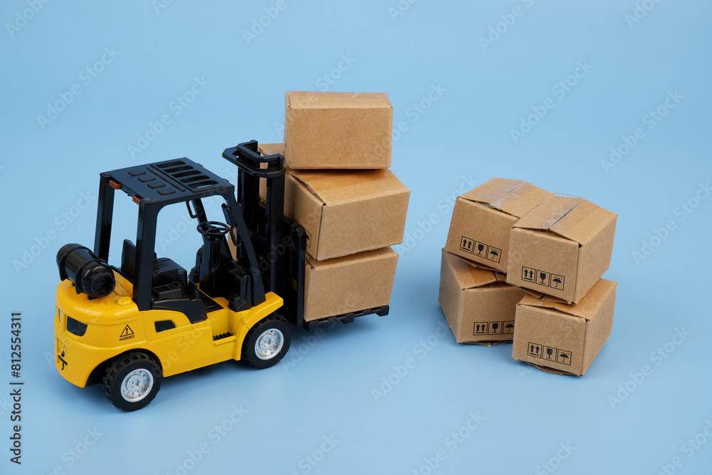 Forklift truck and shipping carton boxes on blue background. Industry and cargo concept. Forklift truck and shipping carton boxes on blue background. Industry and cargo concept.