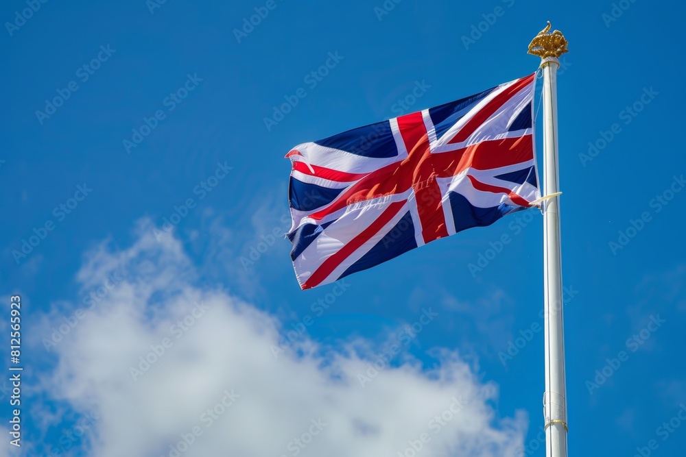 Union Jack flag flying against a clear blue sky, representing British heritage and pride. British flag Union Jack flag flying against a clear blue sky, representing British heritage and pride. British flag