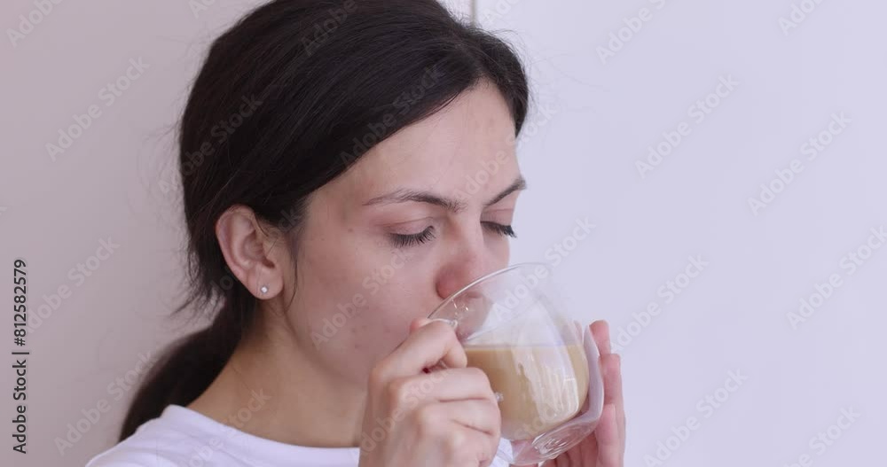 young woman drinking coffee near window at home. young woman drinking coffee near window at home.