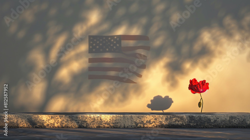 A minimalist yet powerful image of a single red poppy in front of a stark white tombstone with a shadow of an American flag cast upon the scene by the setting sun. photo