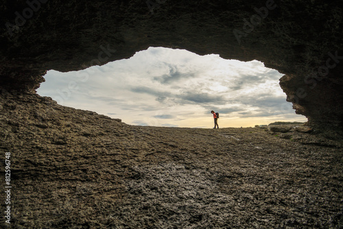 Silhouette of a person at the entrance to a cave photo