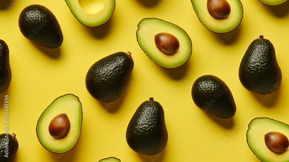 Avocados halved on yellow background, natural food ingredient Avocados halved on yellow background, natural food ingredient