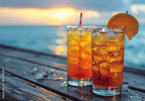 Two colorful cocktails with ice cubes and an umbrella on the deck of a cruise ship, blue ocean in the background