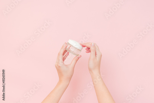 Hand holding glass clear cosmetics jar for face or skin cream. Package for cosmetic beauty product, luxury makeup container © Anton Tolmachov