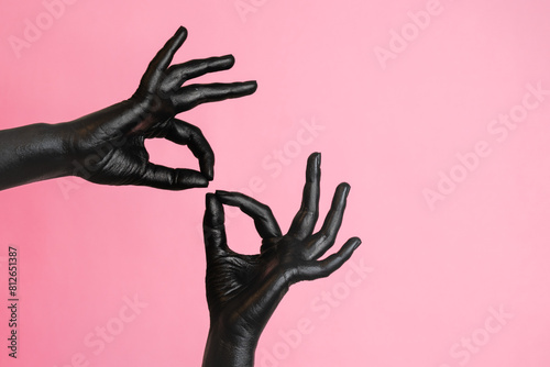 Gesticulation of black painted elegant woman's hands on her skin. High Fashion art concept photo