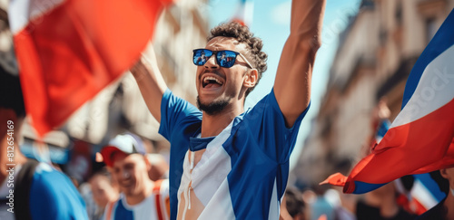 Joyful sports fan celebrating victory with flags at a festive parade. photo