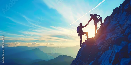 Reaching New Heights Together: Silhouette of Man Helping Another Person Climb to the Top photo