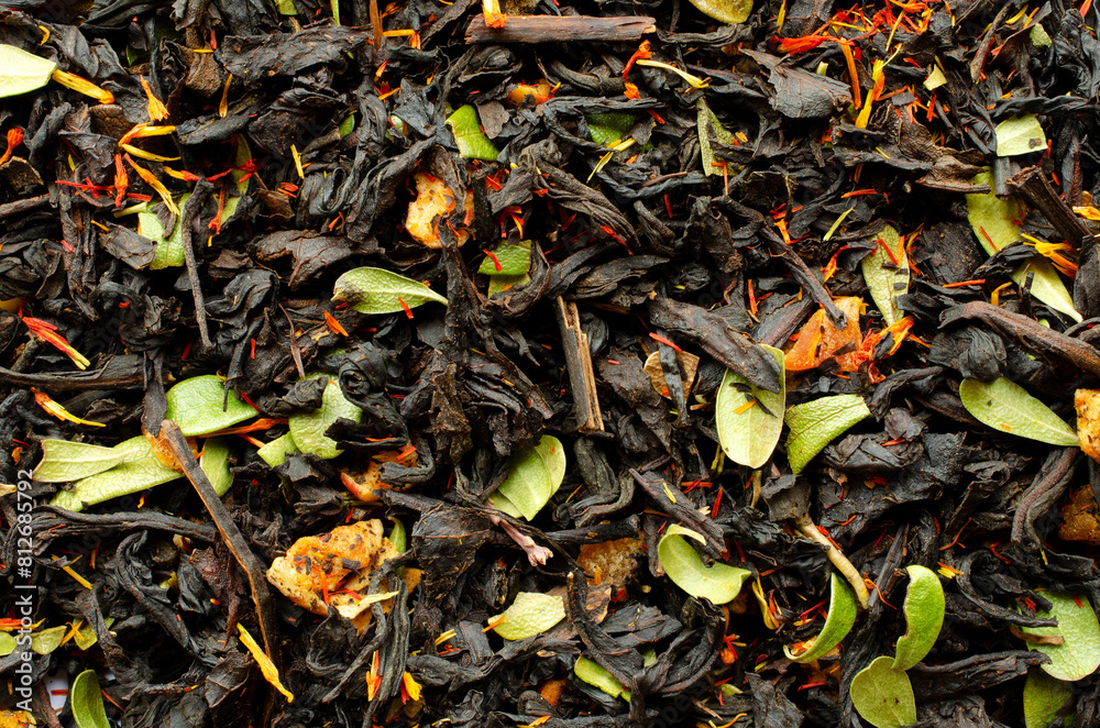 Large amount of dry black tea with pieces of fruit, tasty and aromatic black tea. Background and texture of dry fruity black tea. Dry black fruit tea, background, texture, top view. Large amount of dry black tea with pieces of fruit, tasty and aromatic black tea. Background and texture of dry fruity black tea. Dry black fruit tea, background, texture, top view.