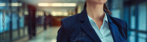 Detail shot of a female executives torso in a black business suit, focused on the sharp lines against a minimalist white backdrop