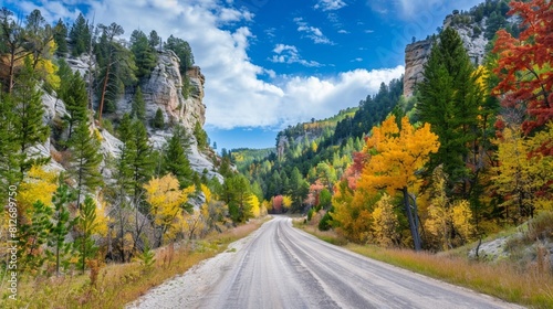 Spearfish Canyon with colorful trees and an empty road under a blue sky in South Dakota