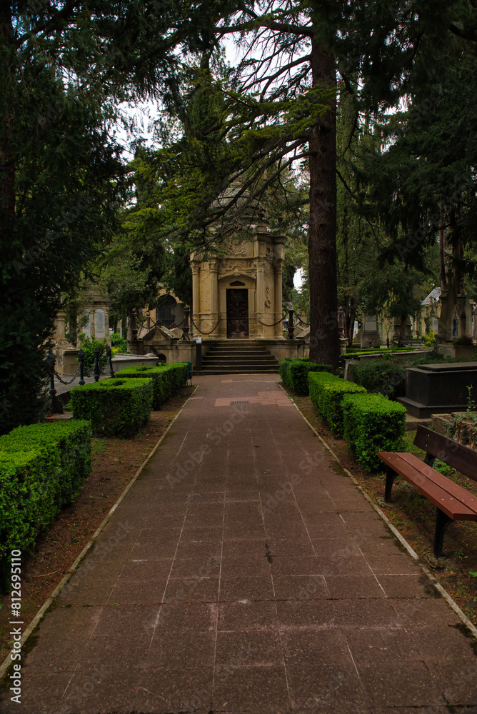 Cemetery aisle, gravestone, cemetery, burial, death, memory, mourning, sadness, grave. Vertical photo of a cloudy day. Cemetery aisle, gravestone, cemetery, burial, death, memory, mourning, sadness, grave. Vertical photo of a cloudy day.