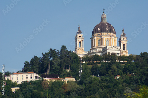 TURIN, ITALY - SEP 14, 2019: Superga, actually Basilica della Nativita di Maria Vergine, an important pilgrimage church near Turin in Italy, photographed from a distance with trees