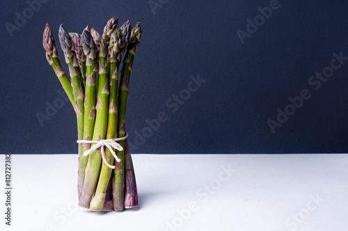 Bundle of asparagus on black background minimalist aesthetic copy space