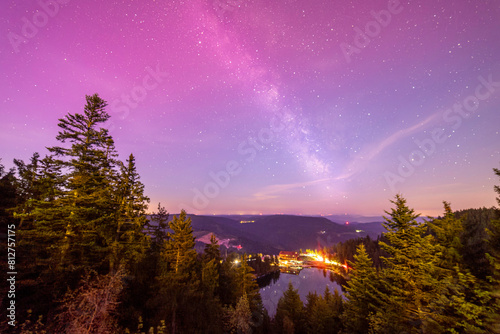 Milky way above Mummelsee in black forest in germany from hornisgrinde with slight red northern lights at top