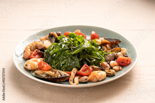Seafood salad served on a plate with arugula sprinkled with sesame seeds