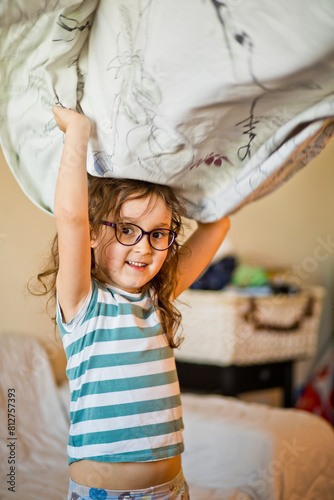 Cute little girl kid child making bed linen at home