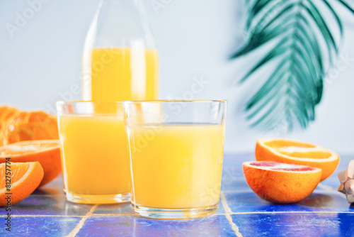 Fresh orange juice on table with slices fruits.