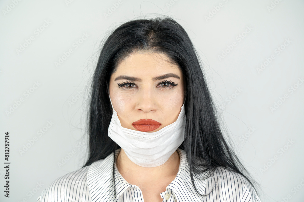 Young woman with surgical mask on face against SARS-CoV-2. COVID-19 Pandemic Coronavirus Young girl in white room wearing face mask Young woman with surgical mask on face against SARS-CoV-2. COVID-19 Pandemic Coronavirus Young girl in white room wearing face mask