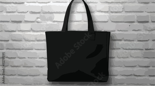Black fabric tote bag hanging on white brick wall -