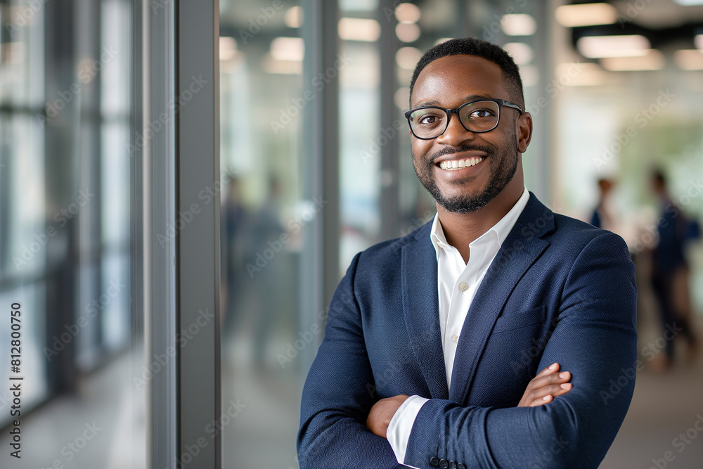 cheerful african american executive businessman at workspace. Portrait of smiling ceo at modern office workplace in suit looking at camera. Happy leader standing in front of company building. cheerful african american executive businessman at workspace. Portrait of smiling ceo at modern office workplace in suit looking at camera. Happy leader standing in front of company building.