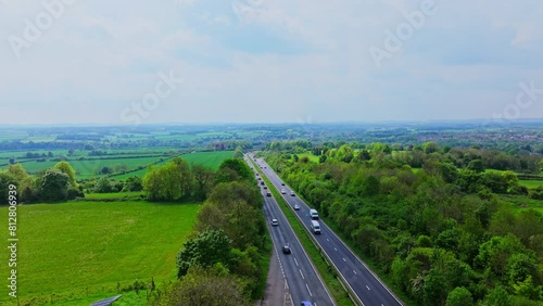 Aerial shot ascending to reveal busy dual carriageway surrounded by rural England photo