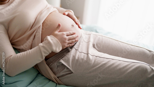 Pregnant woman hand touch on belly caring about baby health.