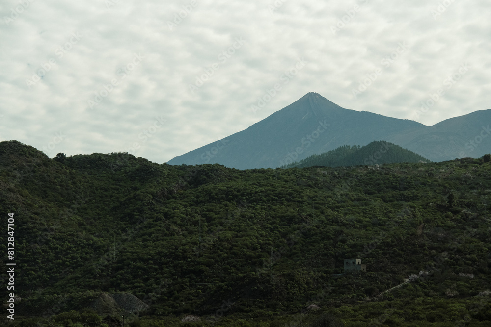 Naklejka premium Scenic mountain view of the volcano Pico del Teide, in national park on the Canary Islands in Spain. Silhouette of the volcano mountain in the distance