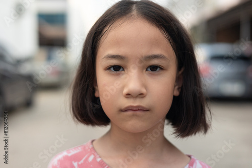 Face and eyes closed up of adorable Asian kid girl who is looking and staring outdoor with serious and concerned emotional expression shows concept of worried problem of z generation child.
