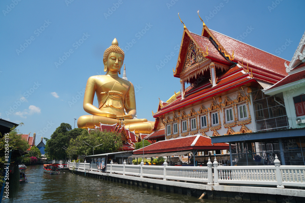 Fototapeta premium Big Golden Buddha Statue in Wat Pak Nam Phasi Charoen or Pak Nam Temple - It is famous for its large seated Buddha that is the largest in Bangkok Thailand - Travel Sculpture and Architecture Religion