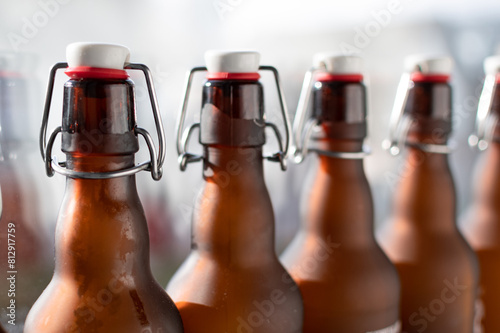 Bottle neck with bugel stopper. A row of brown glass bottles held up to the light. photo