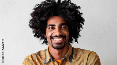 Joven afroamericano sonriente con camisa estampada en fondo neutro