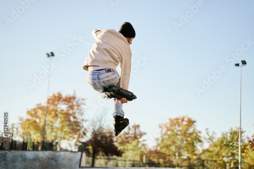 Male skater practising inline skate jumps photo