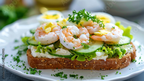 Nutritious avocado toast with shrimp, eggs, cucumber, and fresh herbs on a white plate for a healthy meal option