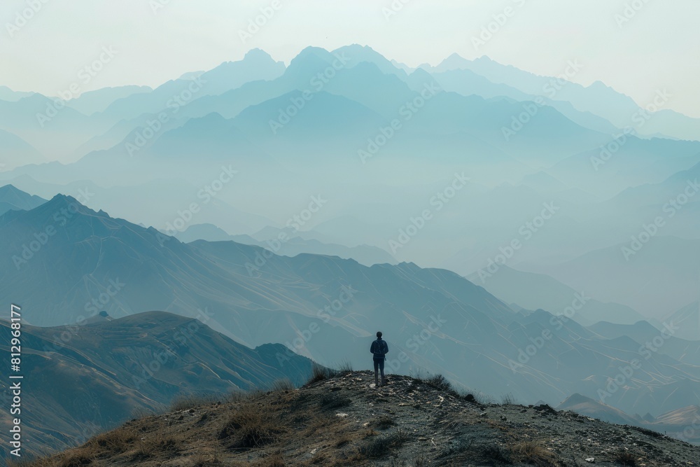 a lone hiker stands with their back to the camera, gazing out at the obscured view with a sense of disappointment.