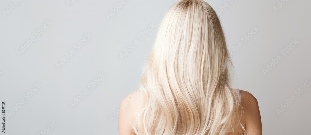 Naklejka premium The back view of shiny blonde hair provides a copy space image for text showcasing healthy strands
