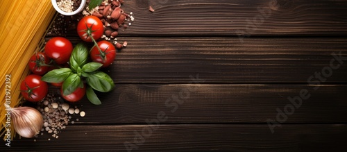Top view copy space image of Italian food ingredients including spaghetti and cooking pasta arranged on a wooden table