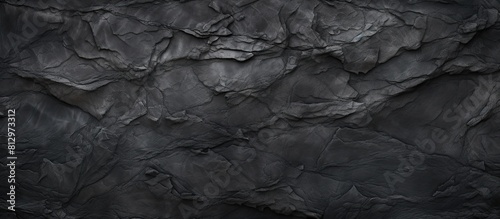 Top view of a textured background in dark grey or black slate providing ample copy space for an image
