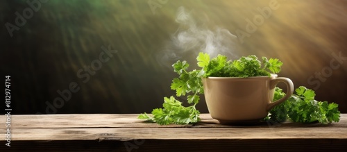 Copy space image of a steaming cup of tea and a bunch of fresh parsley placed on a rustic wooden surface